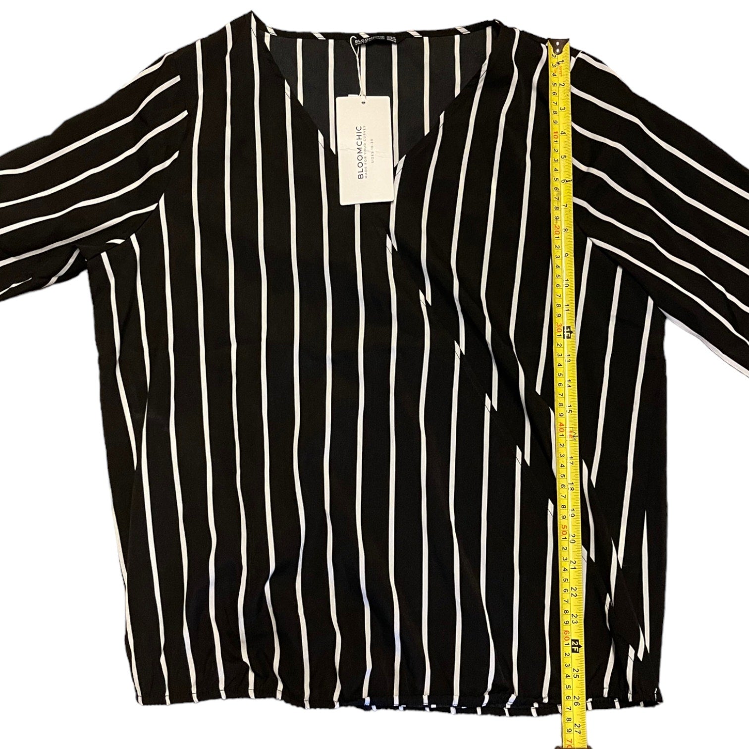 Black and white striped shirt with a measuring tape on a white background