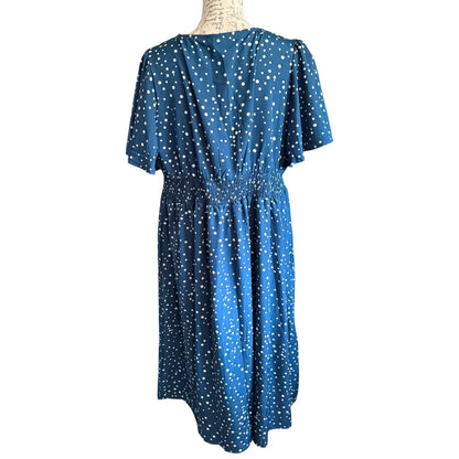 Back of Blue dress with white polka dots on a mannequin against a white background