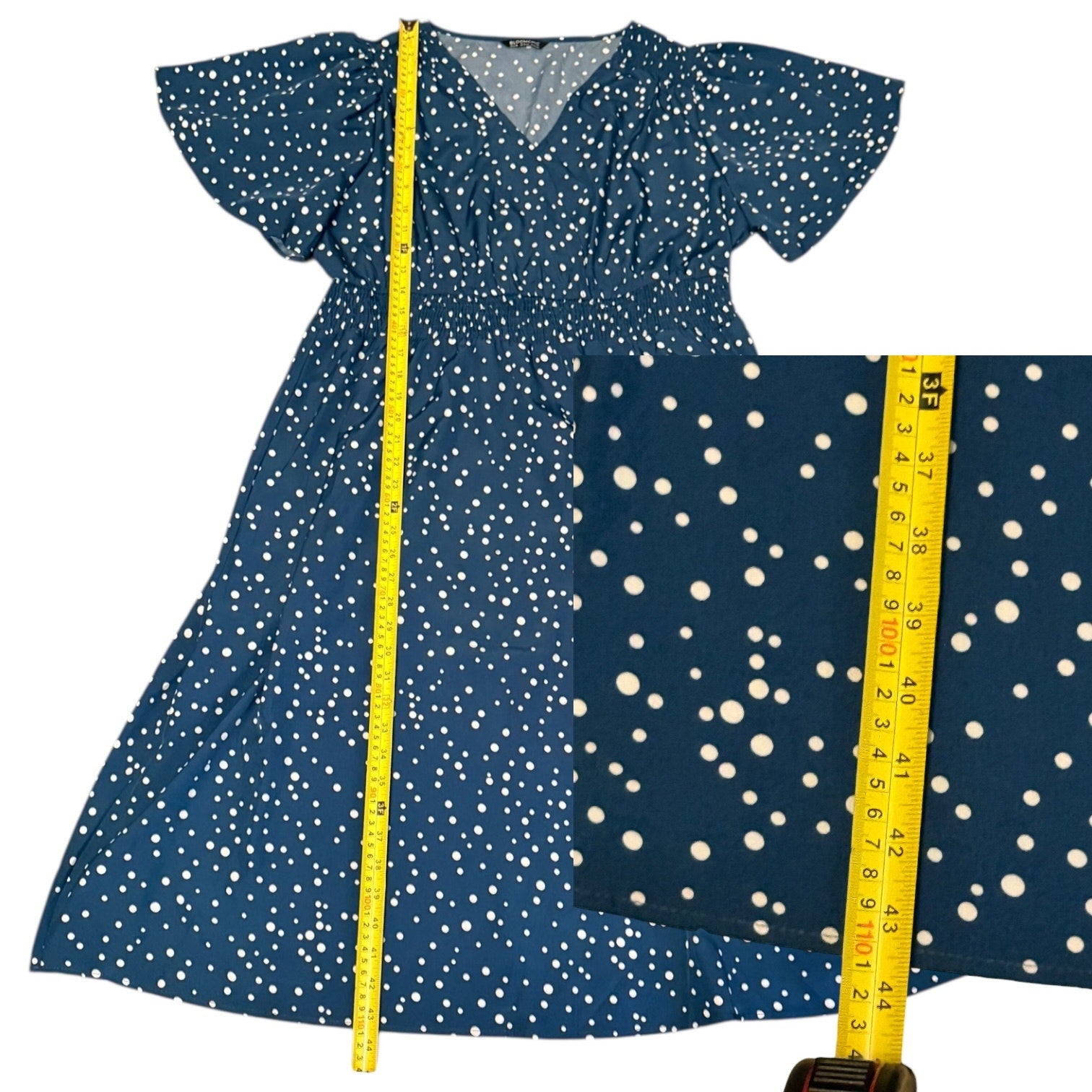 Blue dress with white polka dots and a yellow measuring tape on a white background
