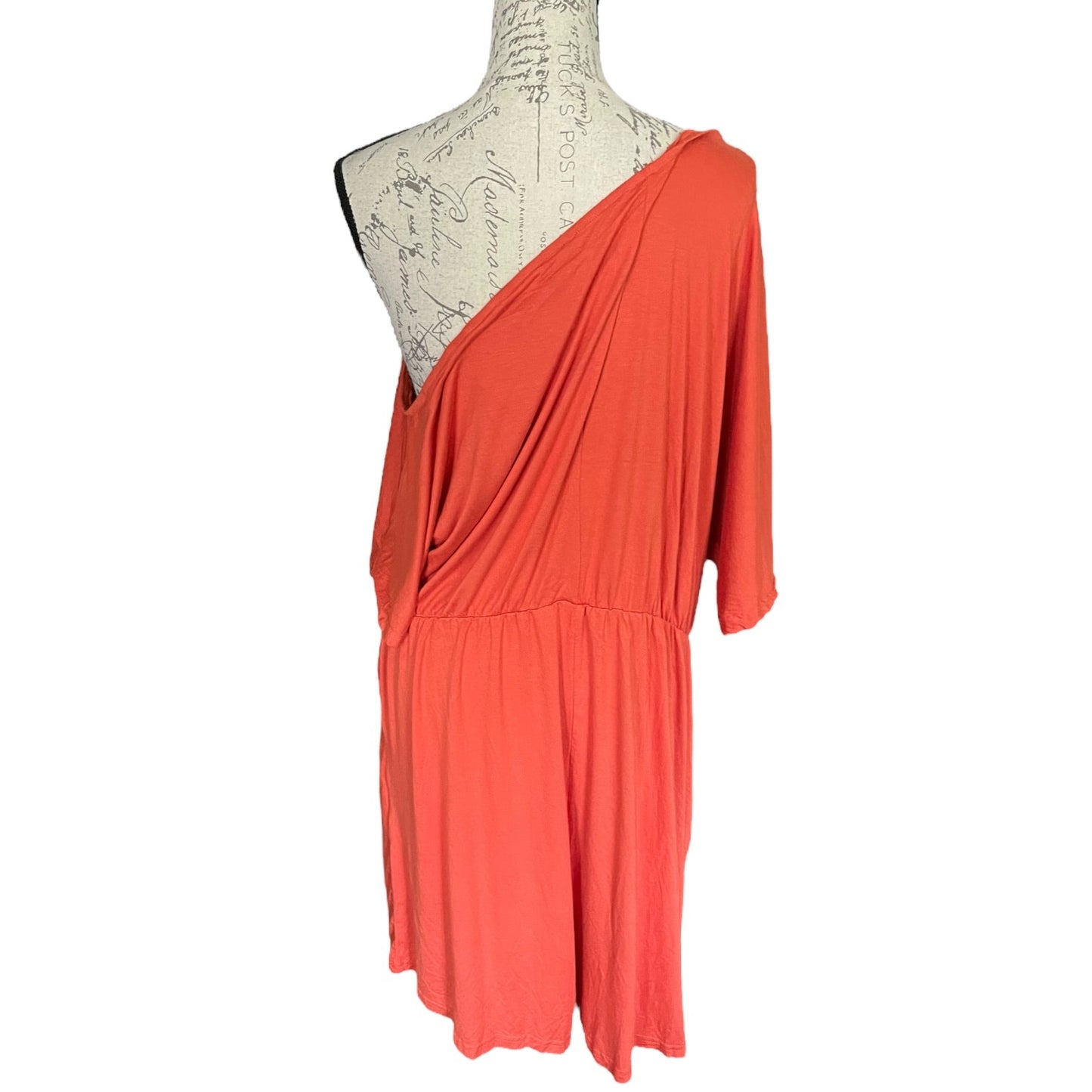 Back of orange romper on a mannequin against a white background