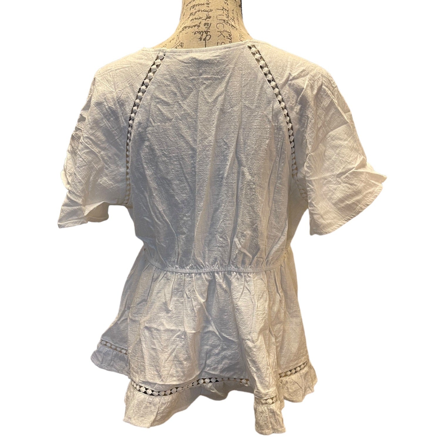 Back of white shirt with cut out details on a mannequin against a white background