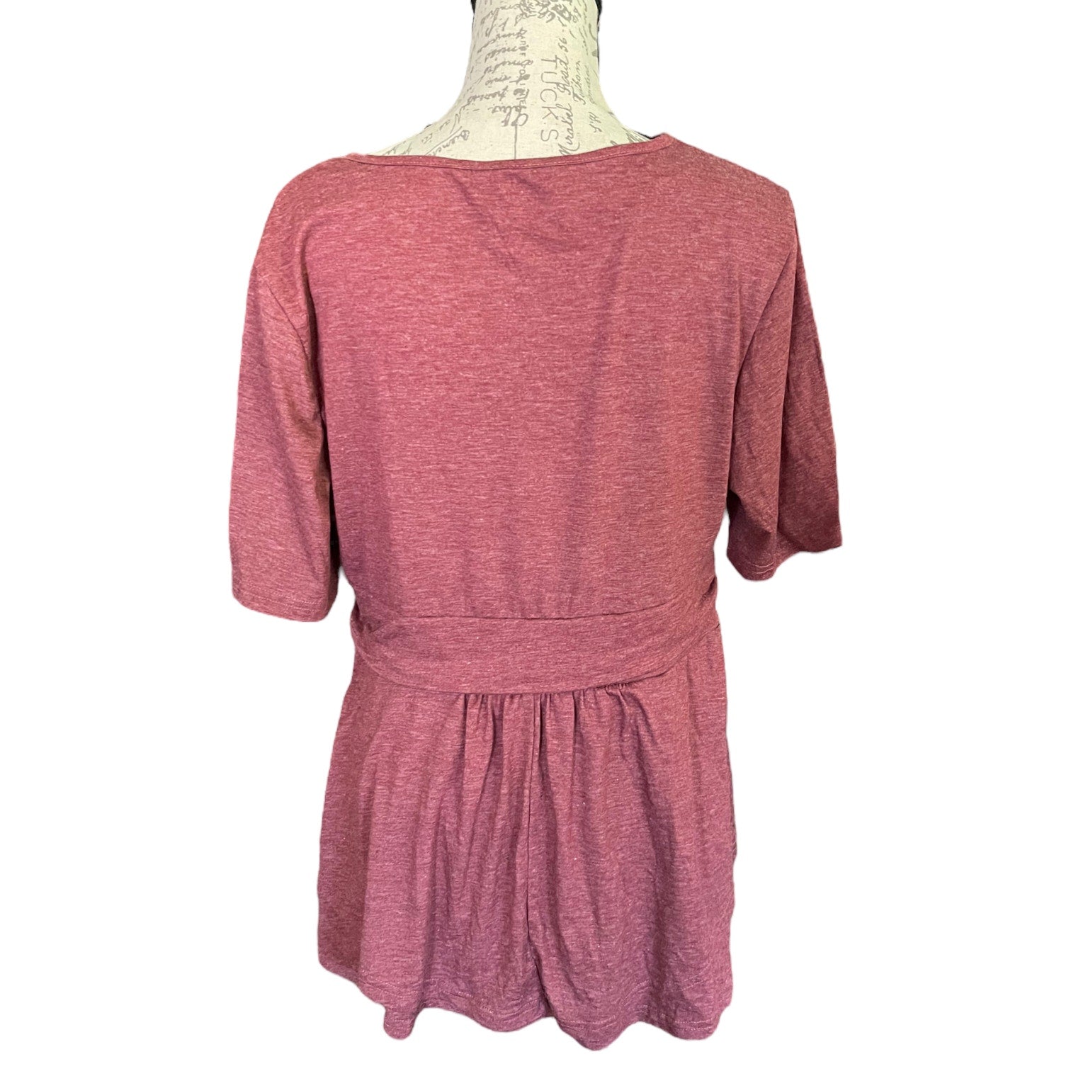 A heathered dusty rose pink short-sleeve top displayed on a dress form mannequin against a plain white background.