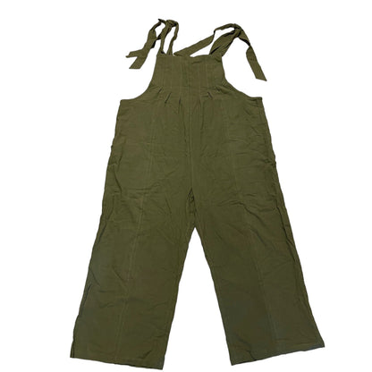 Green overalls with straps laying flat on a white background