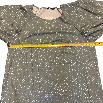 Green shirt with white polka dots and a measuring tape on it