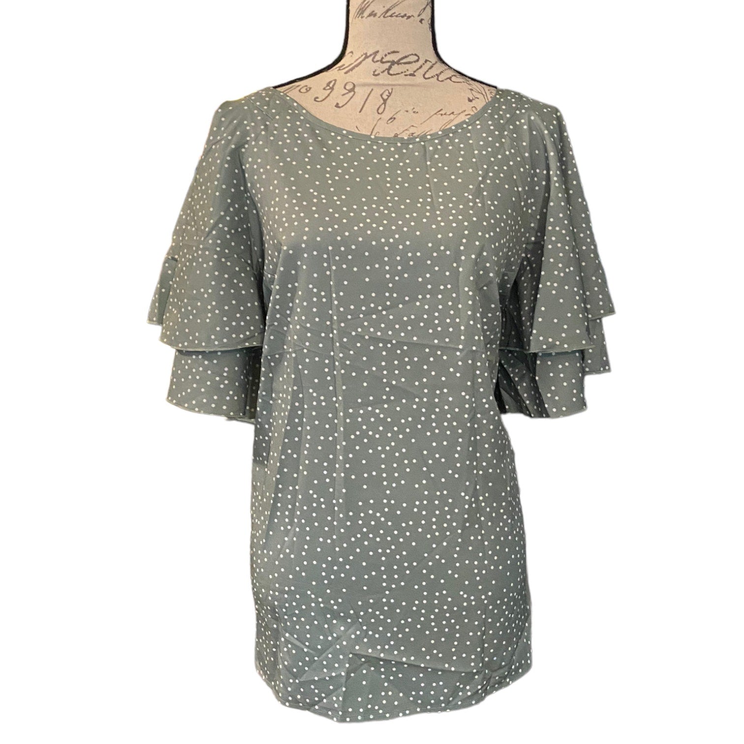 Front of Green polka dot dress on a mannequin with a white background