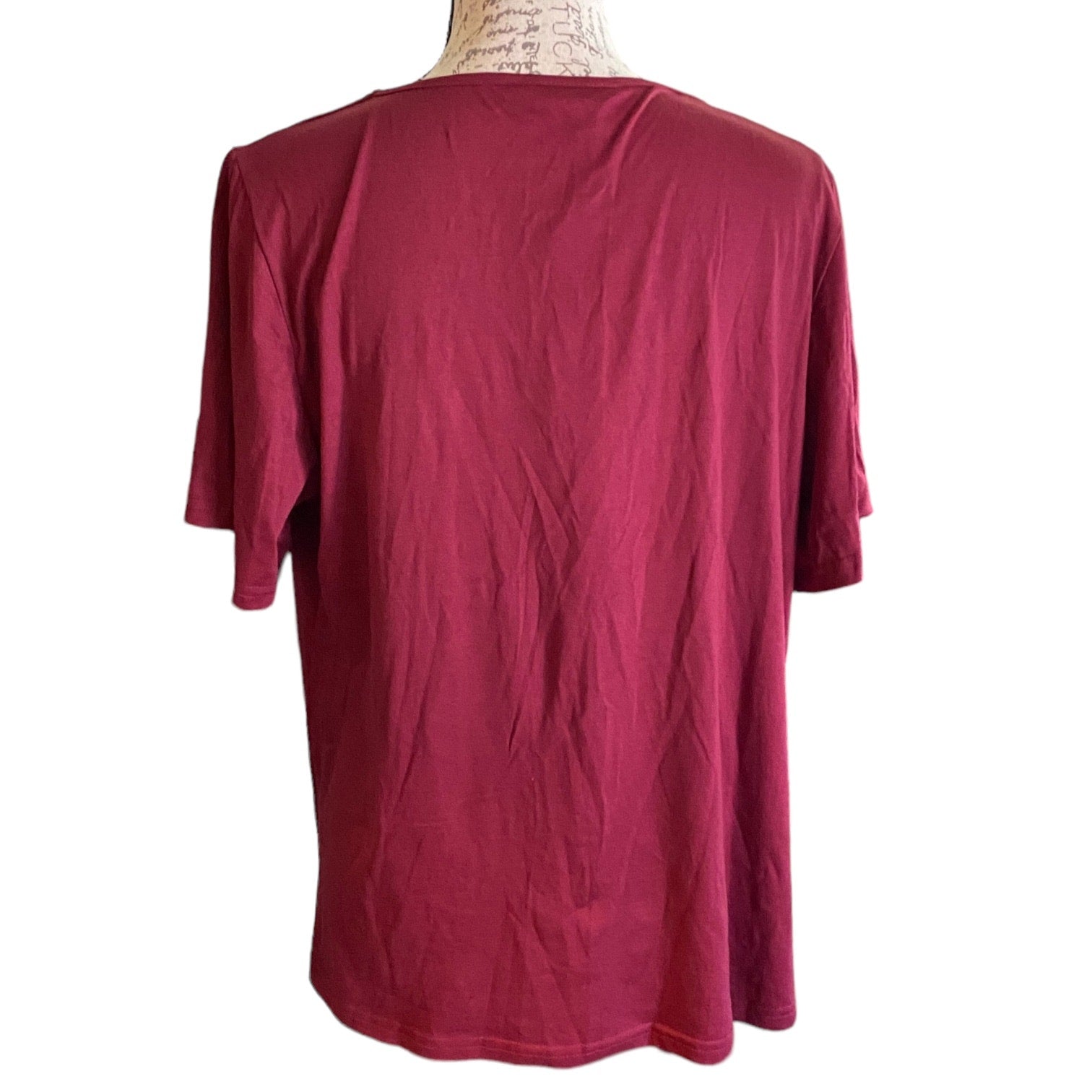 Back of maroon colored shirt, displayed on a mannequin torso against a plain white background.