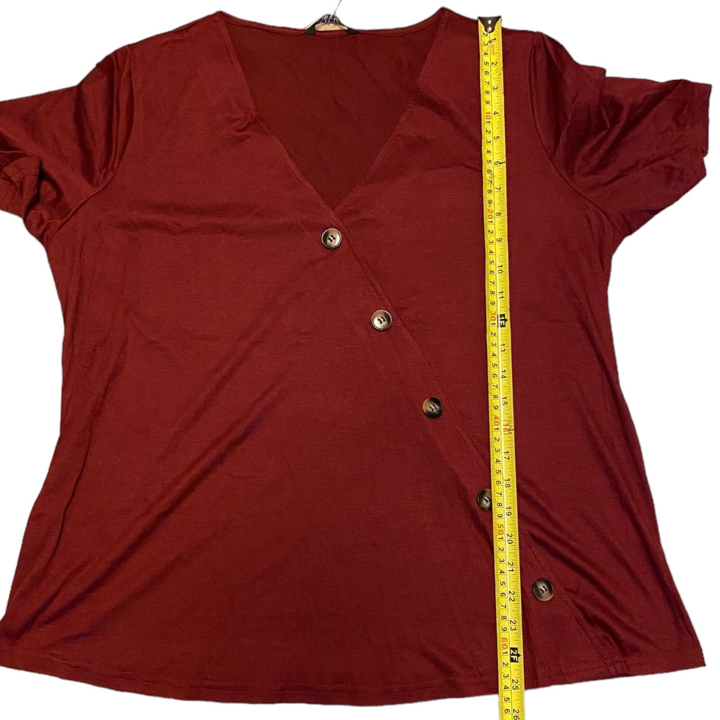 A maroon short-sleeve V-neck top with a buttoned front, shown flat with a yellow measuring tape running vertically along the side to indicate size.