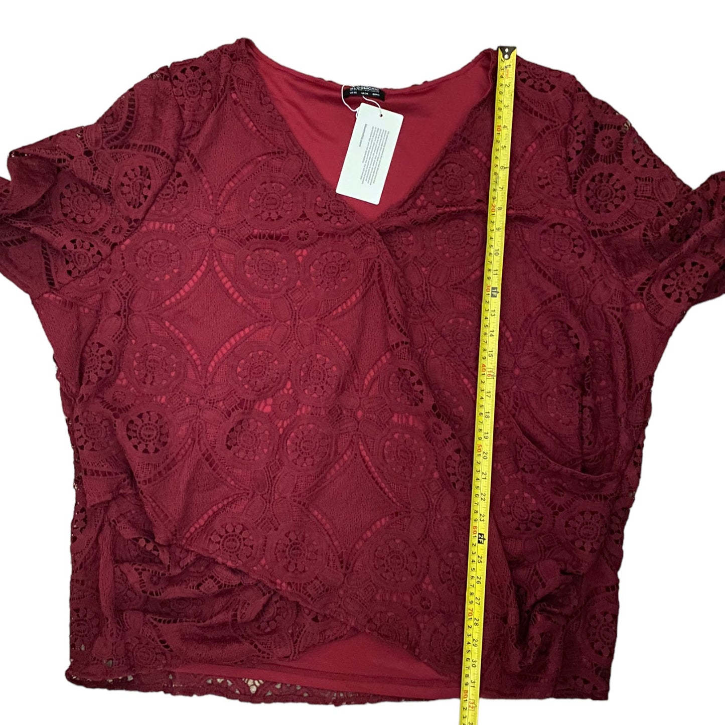 Red lace top with a measuring tape on a white background
