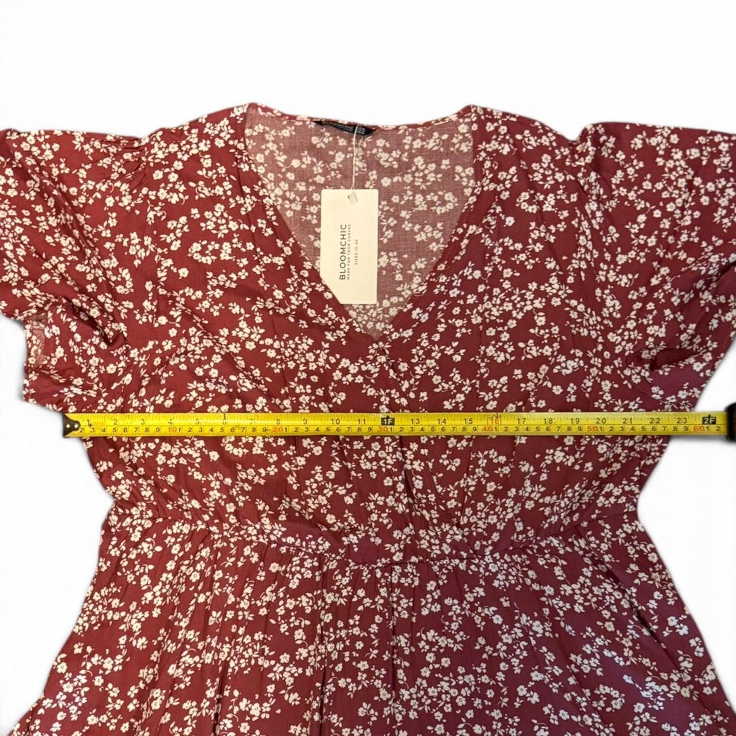 Red floral dress with a measuring tape on a white background
