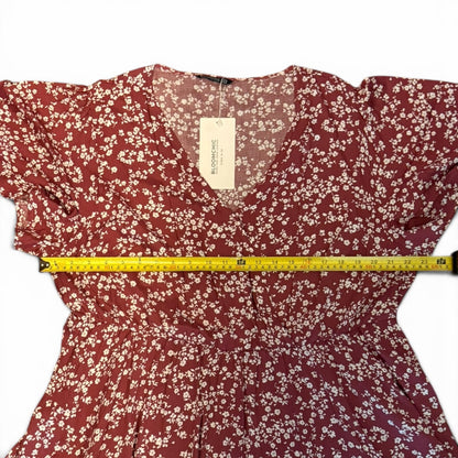 Red floral dress with a measuring tape on a white background