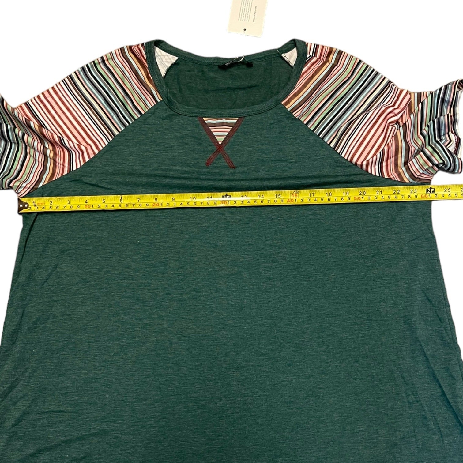 Green t-shirt with colorful sleeves and a measuring tape on a white background