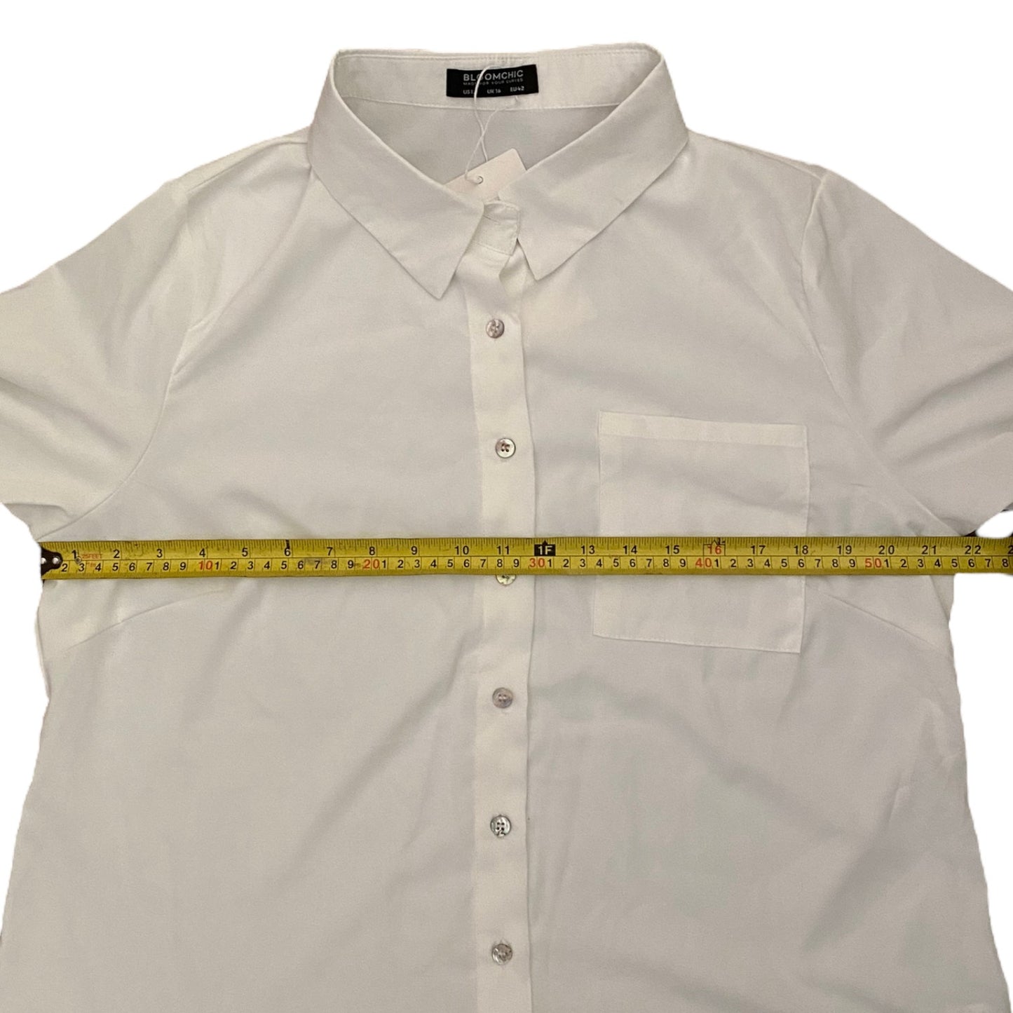 White shirt with a measuring tape laid across it on a white background