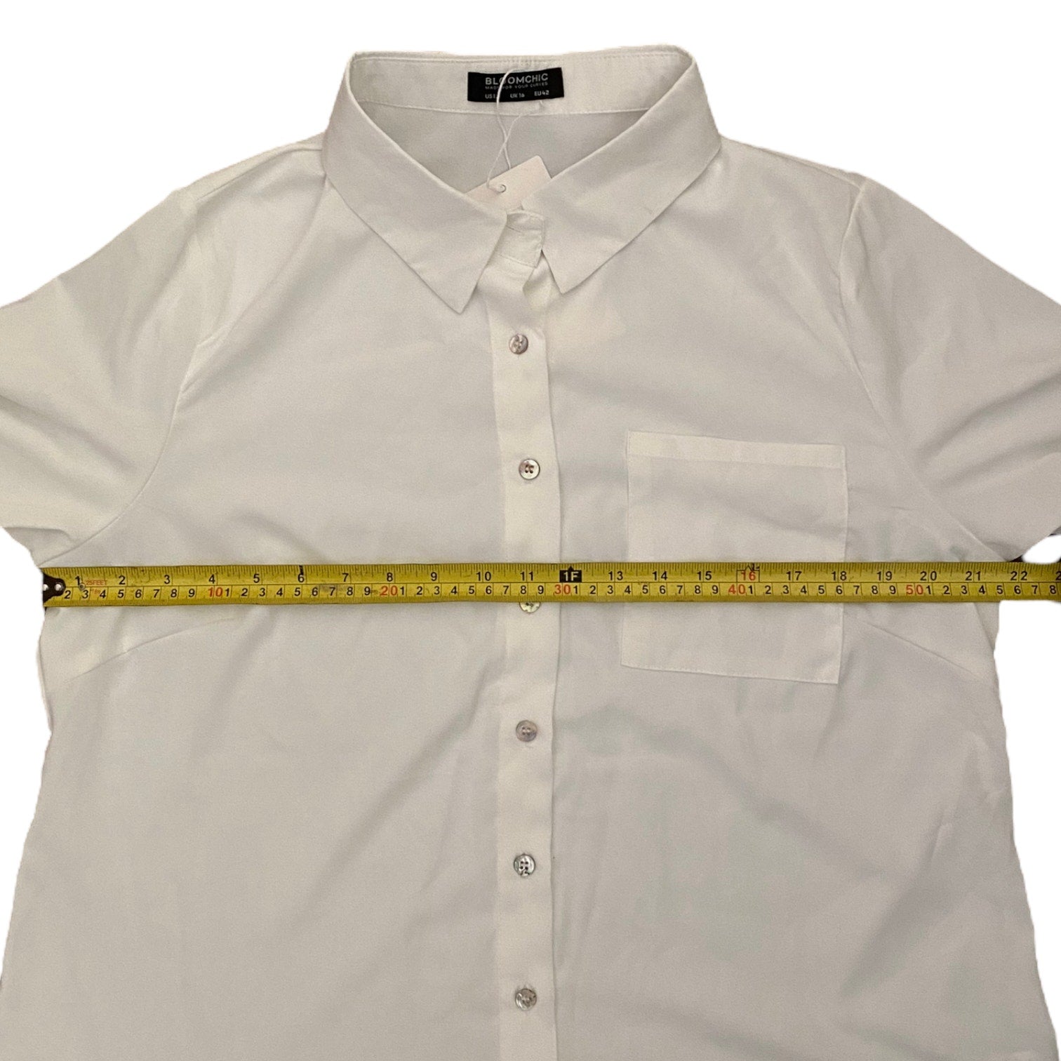 White shirt with a measuring tape laid across it on a white background