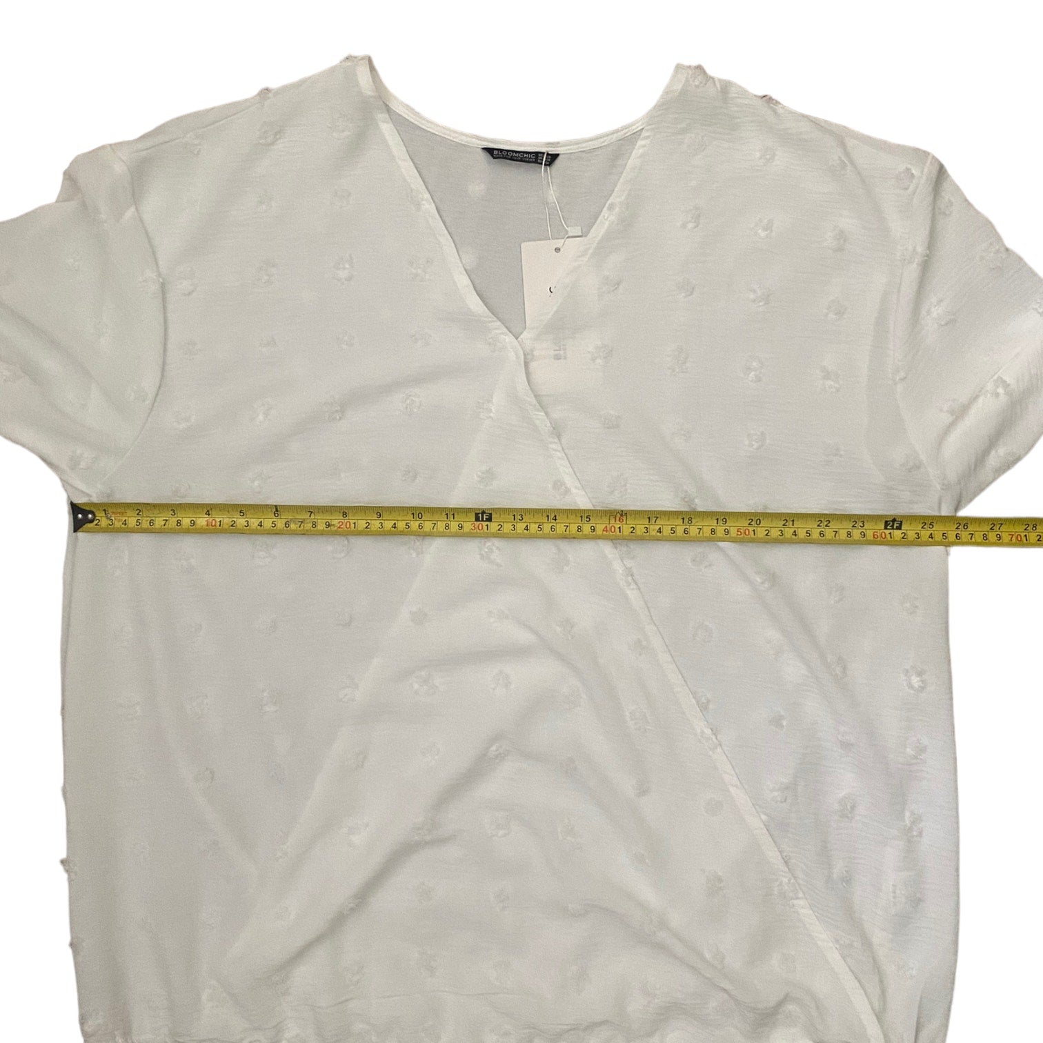 White blouse with a measuring tape across it on a white background