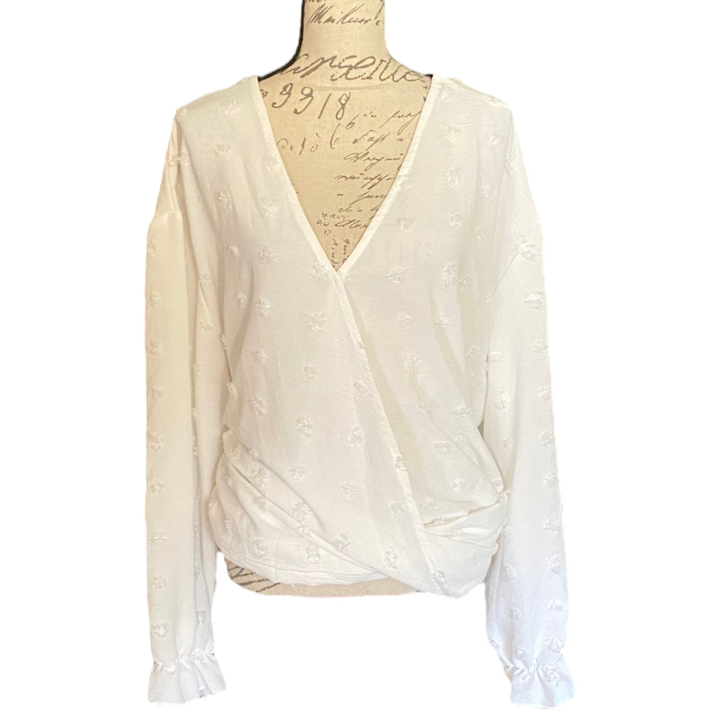 White polka dot top on a mannequin with a white background