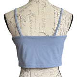 Light blue crop top on a mannequin with a vintage-style script background
