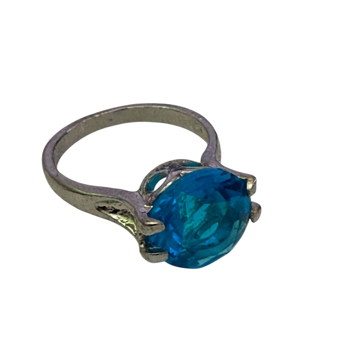 A silver-toned ring featuring a large, faceted oval-cut blue stone in a prong setting, shown against a plain white background.