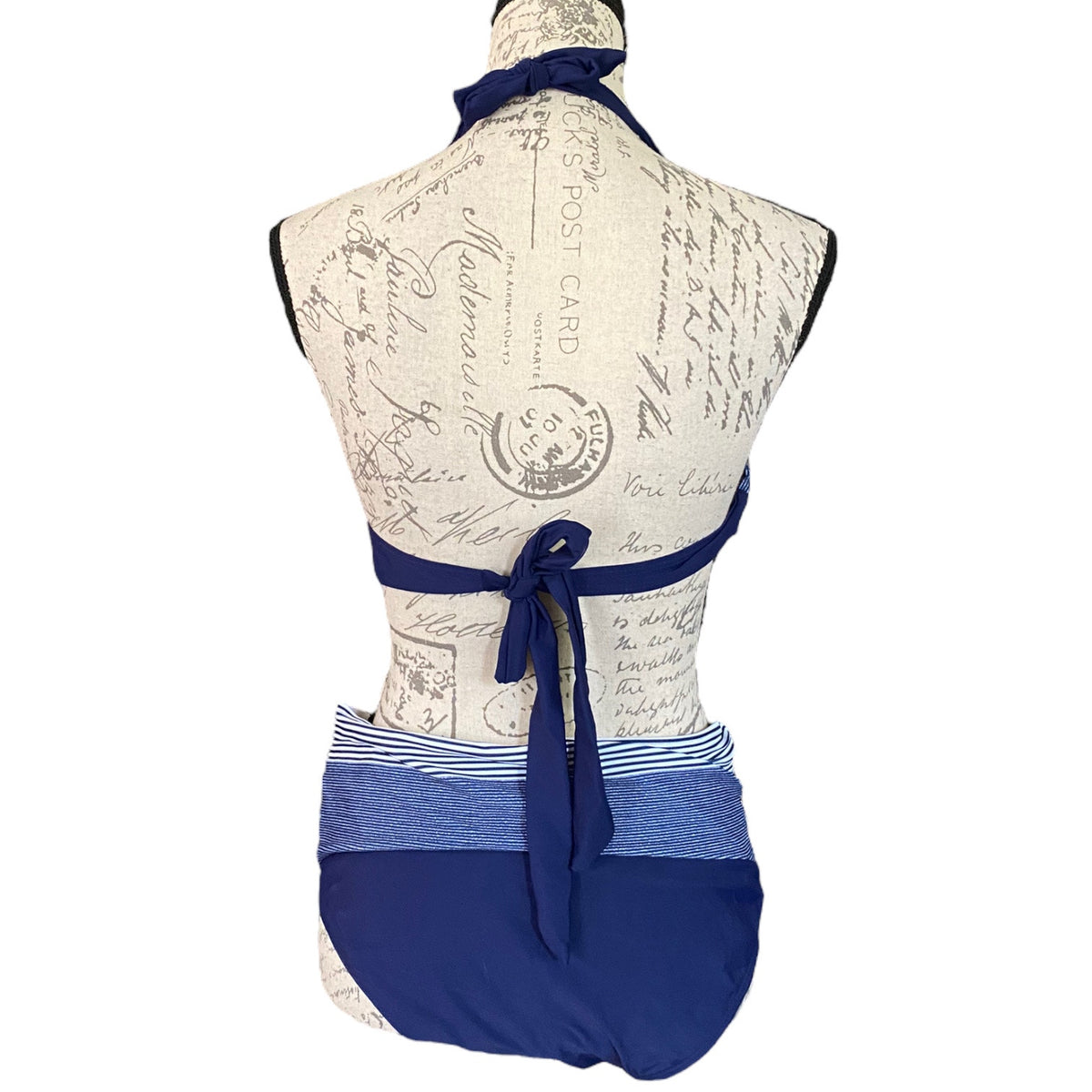Mannequin wearing a blue and white patterned swimsuit with a bow detail on a white background