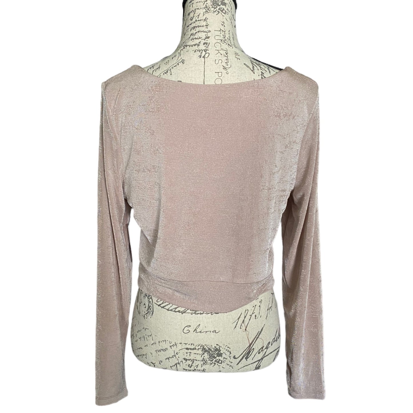 Back of light pink shirt with long sleeves on a white background