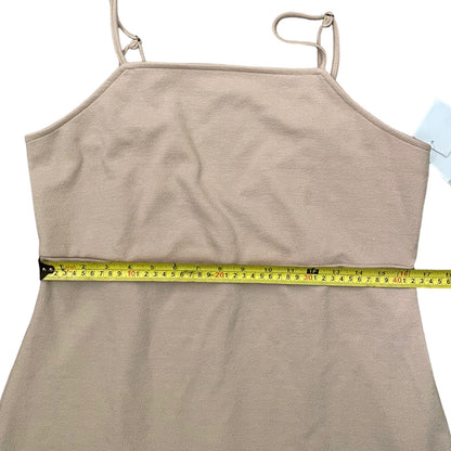 A beige spaghetti-strap dress with a tape measure wrapped horizontally around the waist to show the measurement.