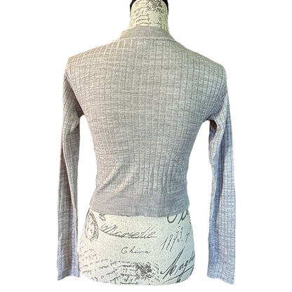 A light gray ribbed knit long-sleeve sweater displayed on a mannequin torso against a plain white background.