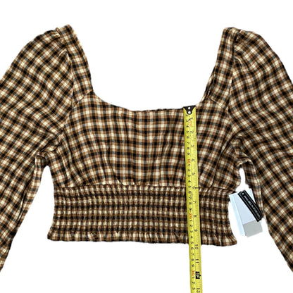 Plaid top with a measuring tape for size reference on a white background