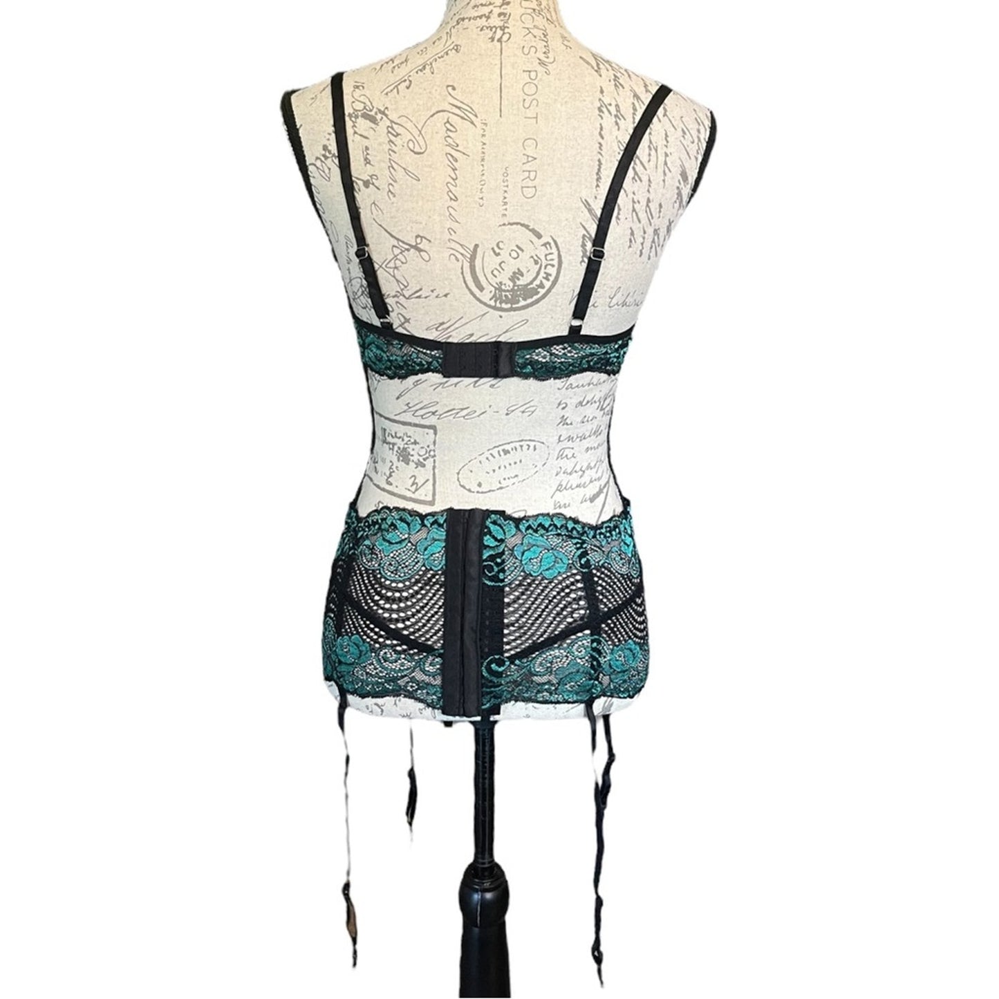Back of black and green lace lingerie on a mannequin against a white background