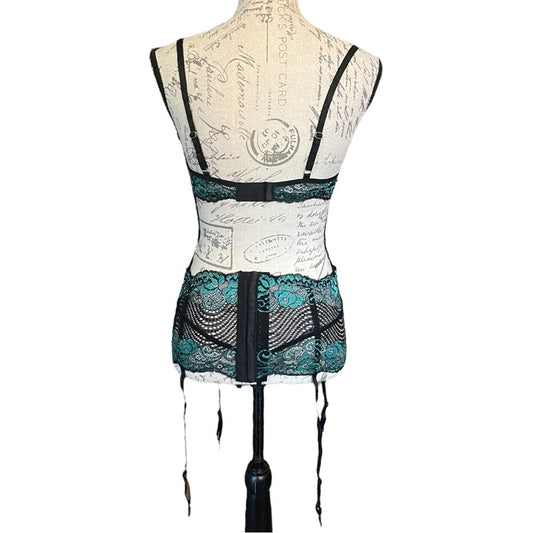 Back of black and green lace lingerie on a mannequin against a white background