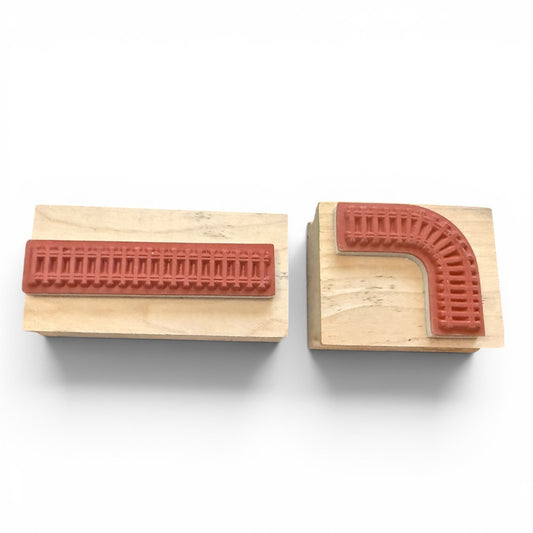 Two wooden stamps with red rubber stamps on a white background