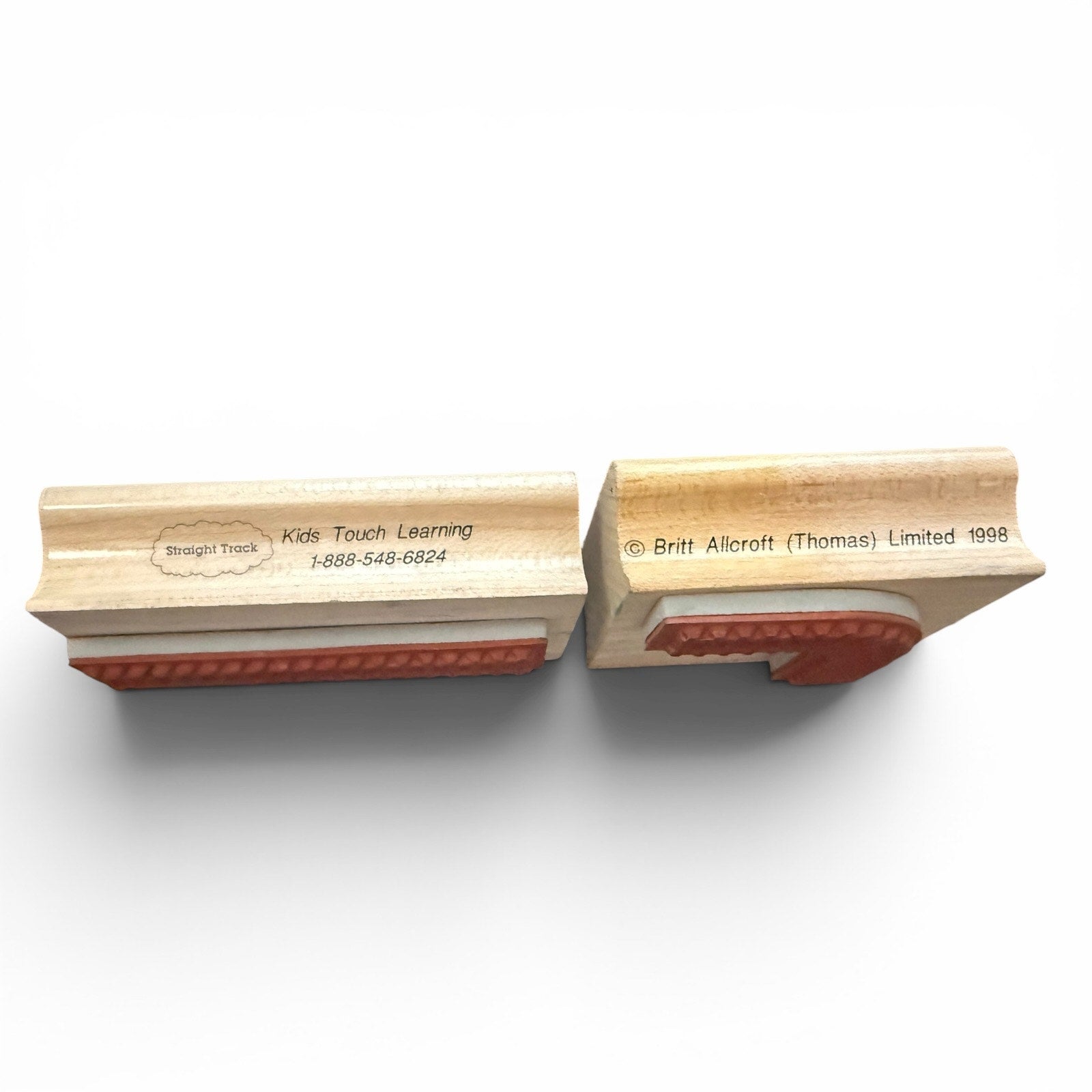 Two wooden stamps with red ink pads on a white background