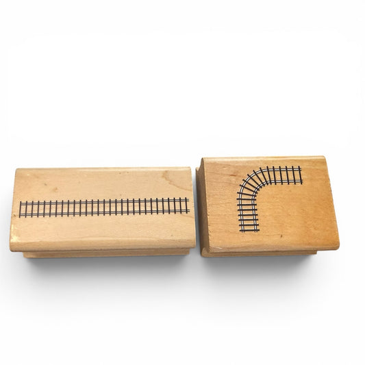 Two wooden stamps with train track designs on a white background