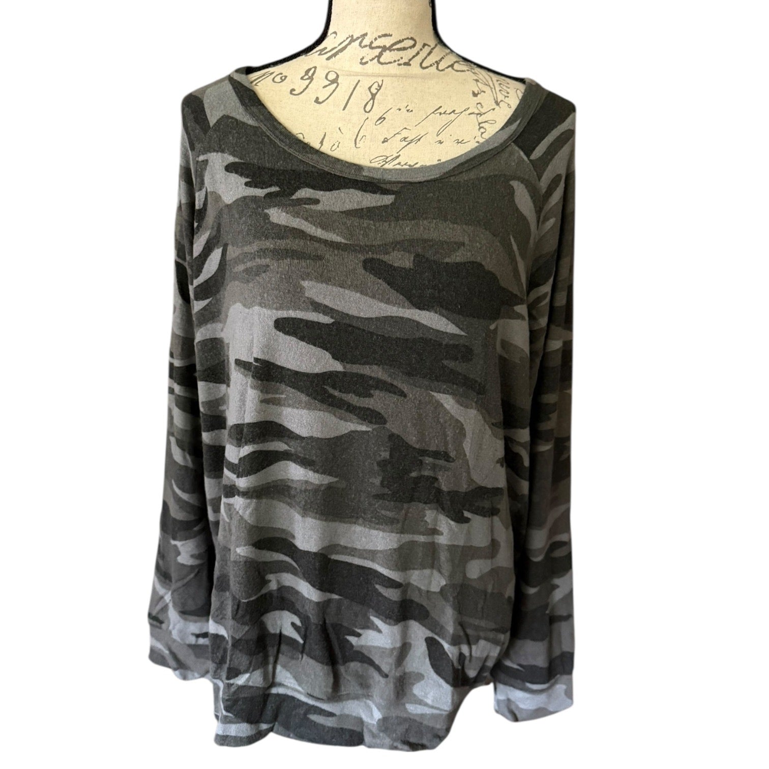 Front of Camouflage-patterned long-sleeve top on a mannequin with a white background