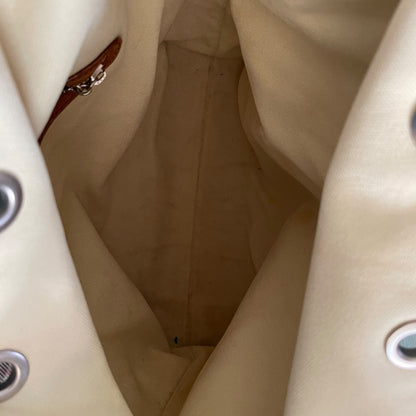 Close-up of a beige fabric interior with a zipper and metal buttons.