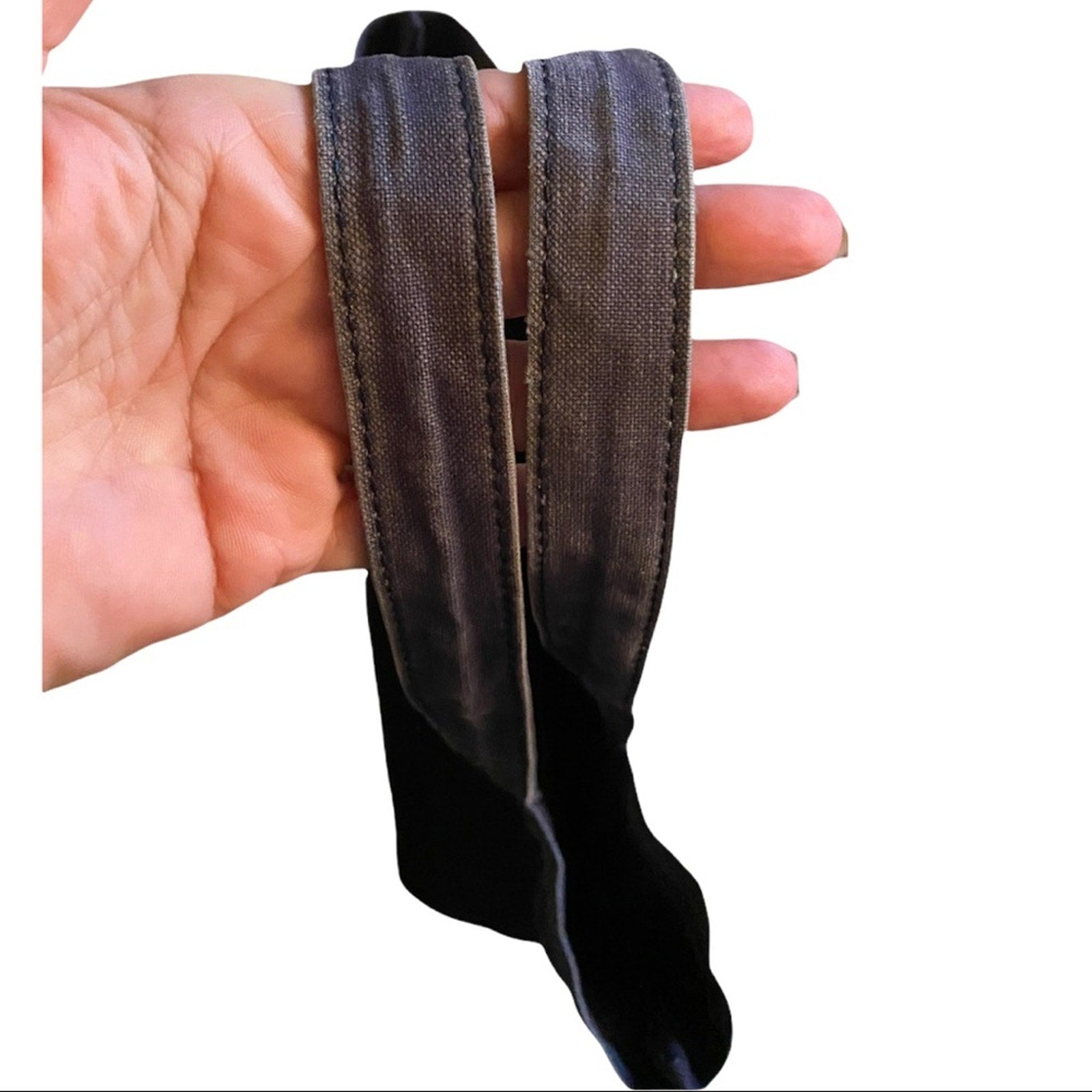 Hand holding blue bag handles with fading on a white background