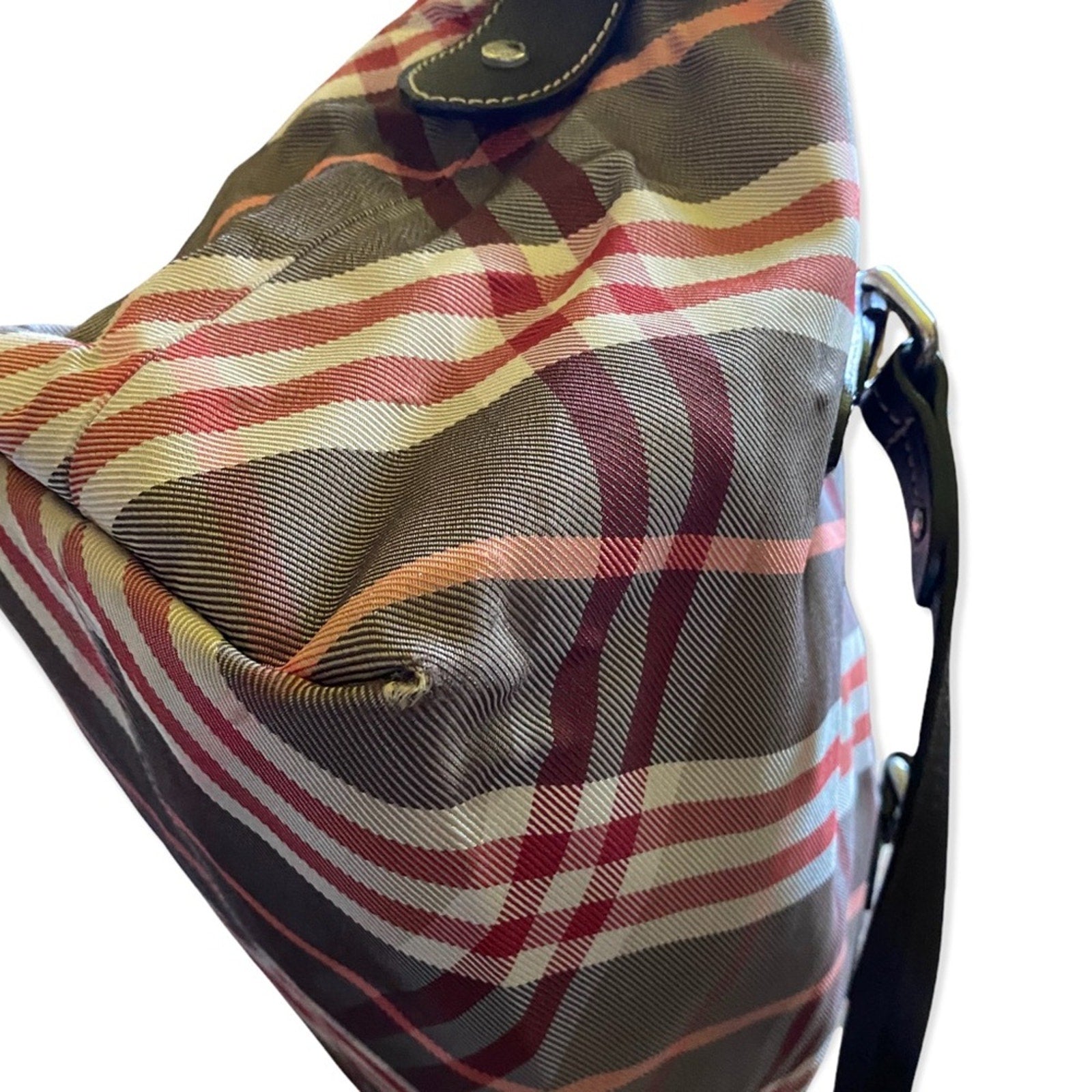 Corners of Plaid patterned bag with a strap on a white background