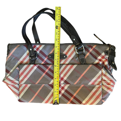 Plaid patterned handbag with a measuring tape for scale on a white background