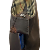 Close-up of a brown leather tab with issues with plaid lining on a white background