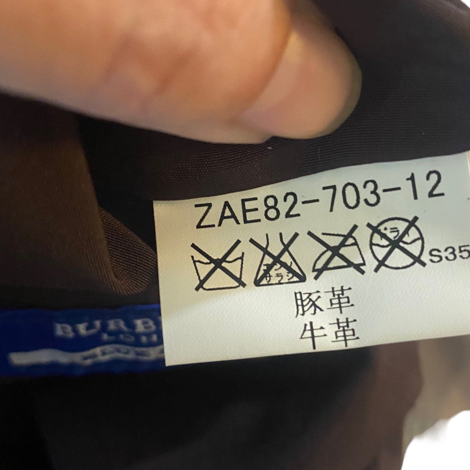 Close-up of a label on a Burberry product with text and symbols.