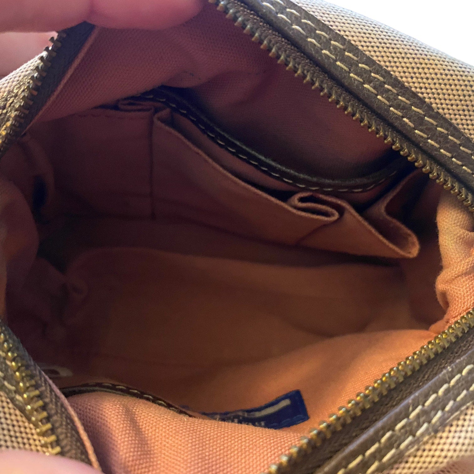 Close-up of interior of pink bag with a visible brand label.