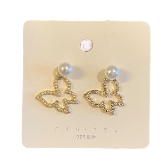 Butterfly-shaped earrings on a branded card with 'NYU NYU' branding.