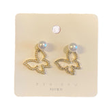 Butterfly-shaped earrings on a branded card with 'NYU NYU' branding.