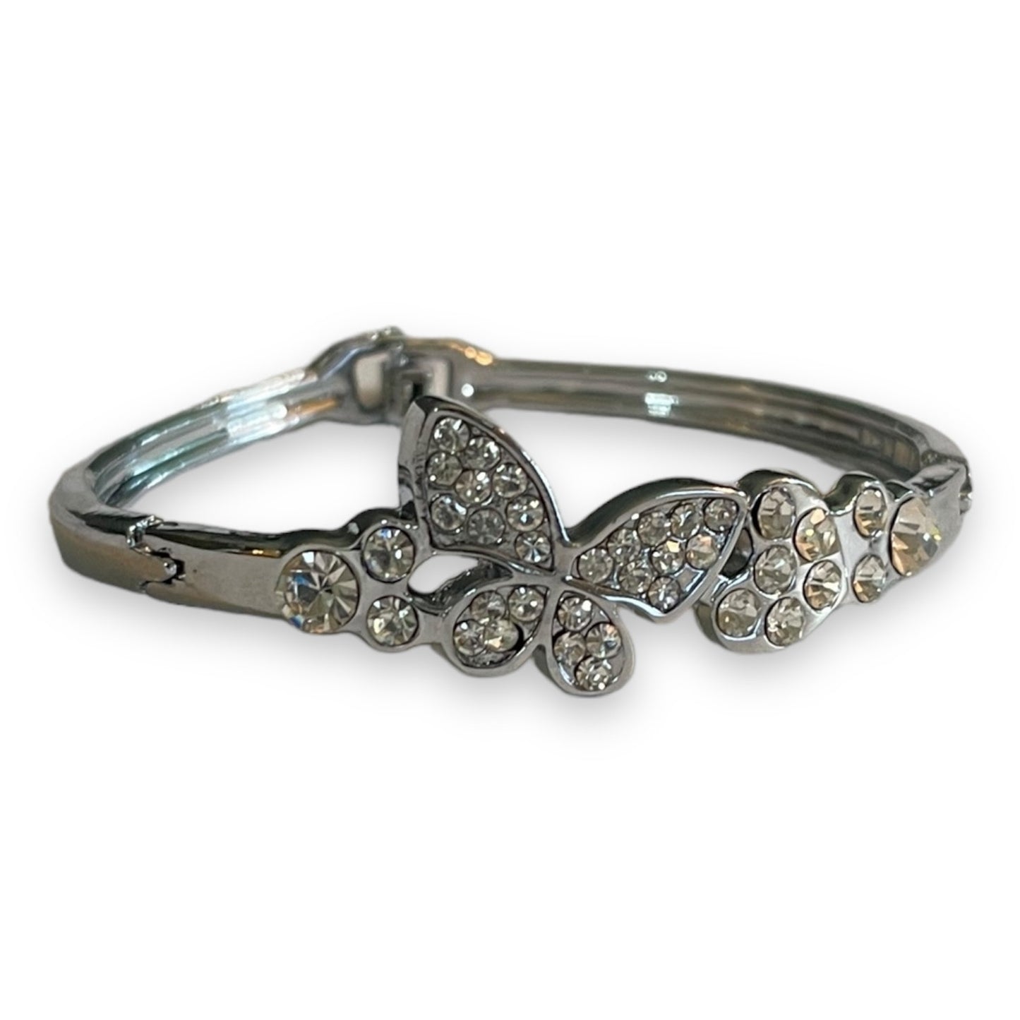 A silver-toned bangle bracelet featuring a butterfly and floral motifs embellished with clear rhinestones, shown on a plain white background.