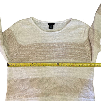 Beige knit top with a measuring tape on a white background