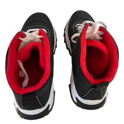 A pair of black sneakers with bright red fleece lining and white laces, shown from a top-down view on a white background.