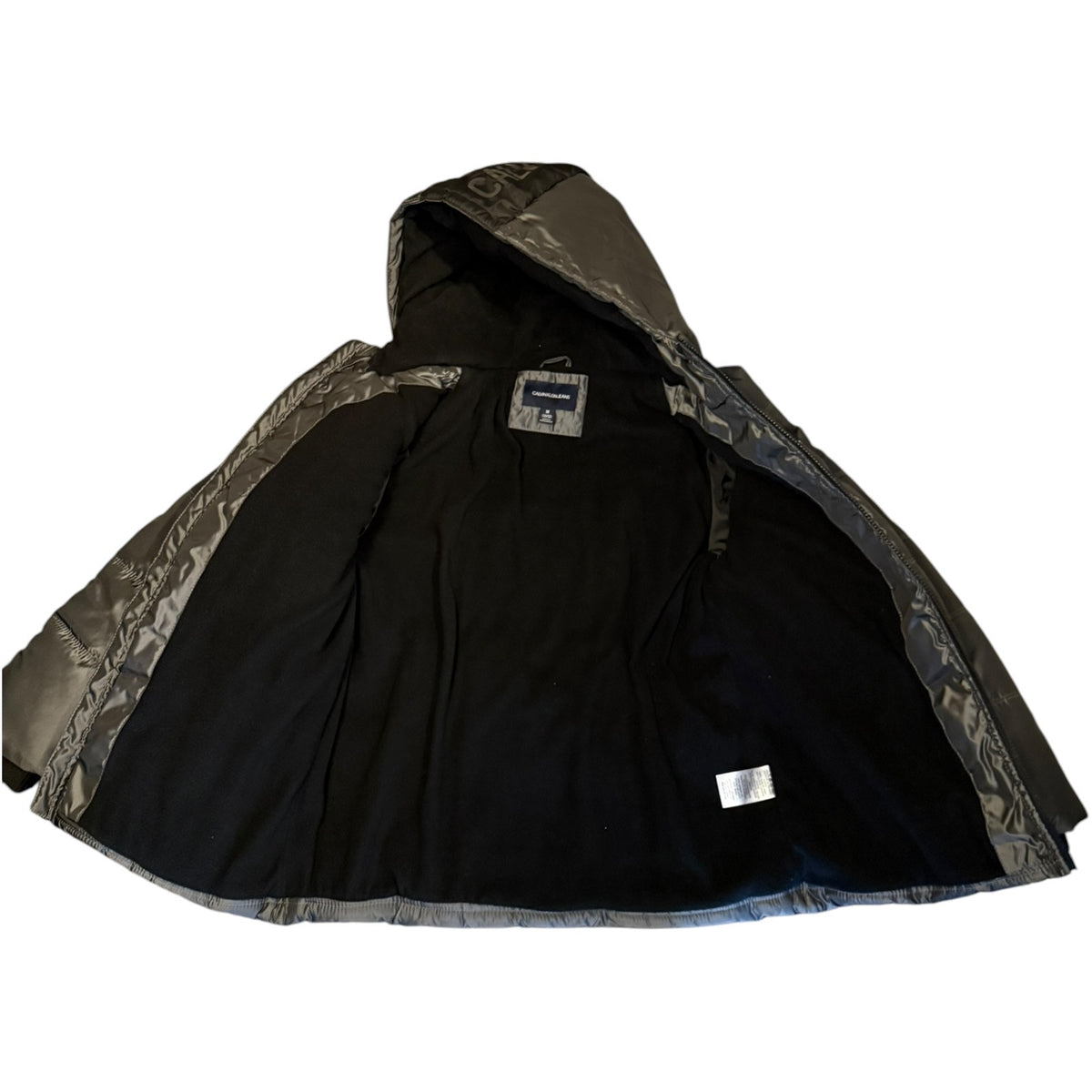 A black interior hooded jacket with shiny silver-gray exterior on the hood and sleeves, laid flat against a white background.