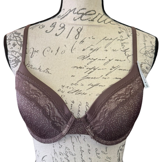 A mauve lace and satin underwire bra displayed on a beige fabric mannequin torso with cursive writing, against a white background.