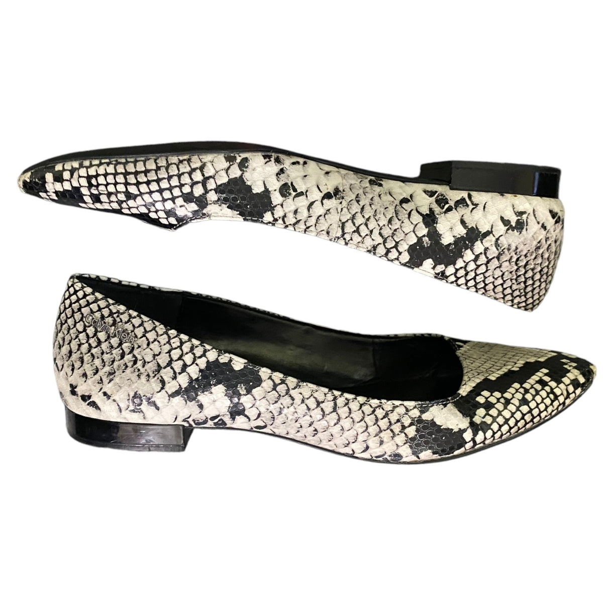 A pair of women's pointed-toe flats featuring a black and off-white python snakeskin pattern, shown against a plain white background.