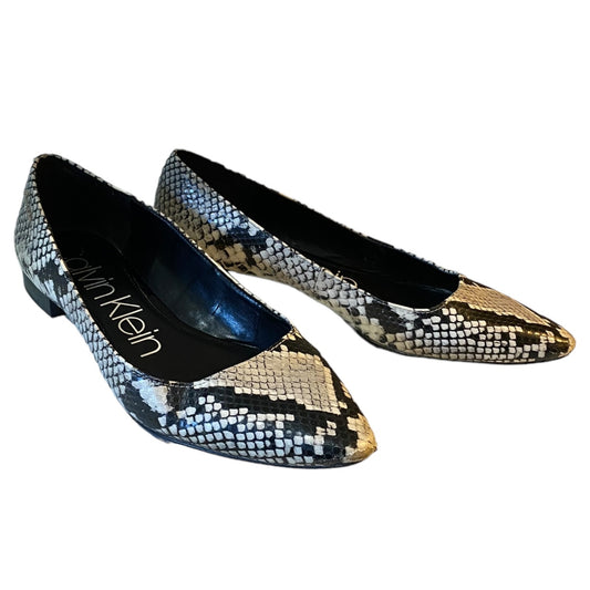 A pair of Calvin Klein pointed-toe flat shoes featuring a black, gray, and beige snakeskin pattern, shown on a plain white background.