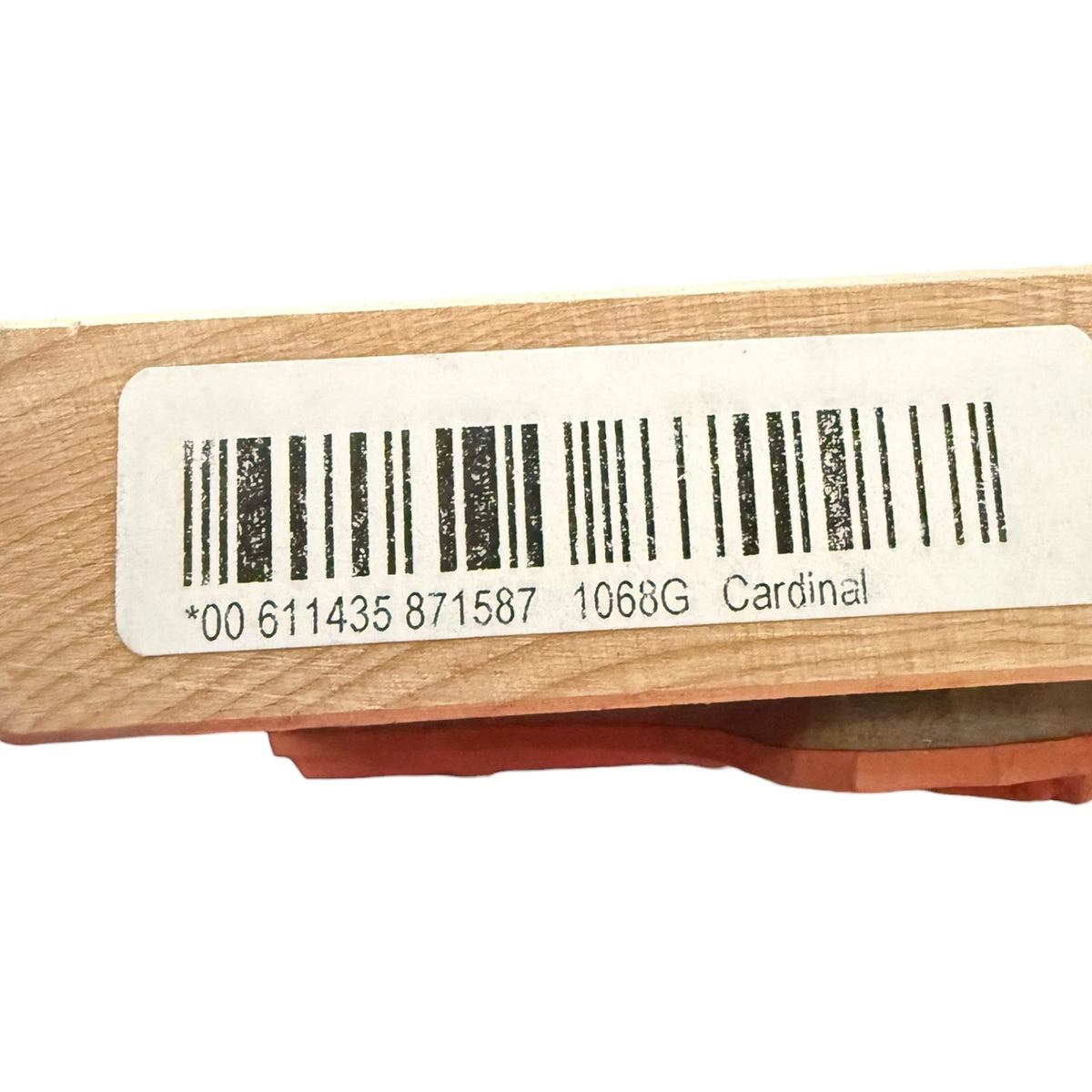 A close-up of a wooden block with a white barcode label printed with a barcode and the text '1068G Cardinal'.