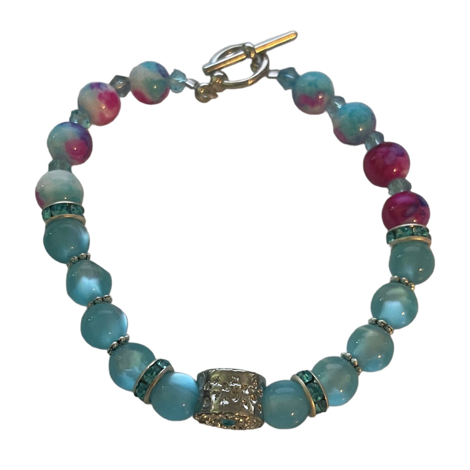 Top of Beaded bracelet with blue, pink, and silver accents on a white background